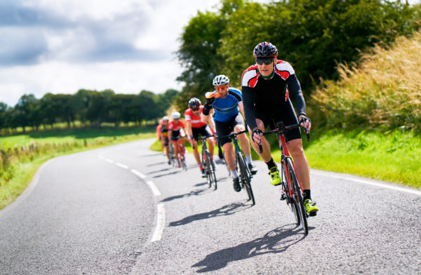 Cyclists,Racing,On,Country,Roads,On,A,Sunny,Day,In